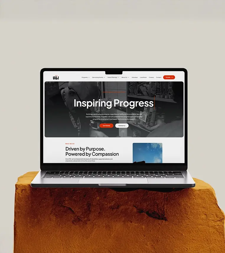 Open laptop displaying Inspiring Progress website — Flinzap web design and development